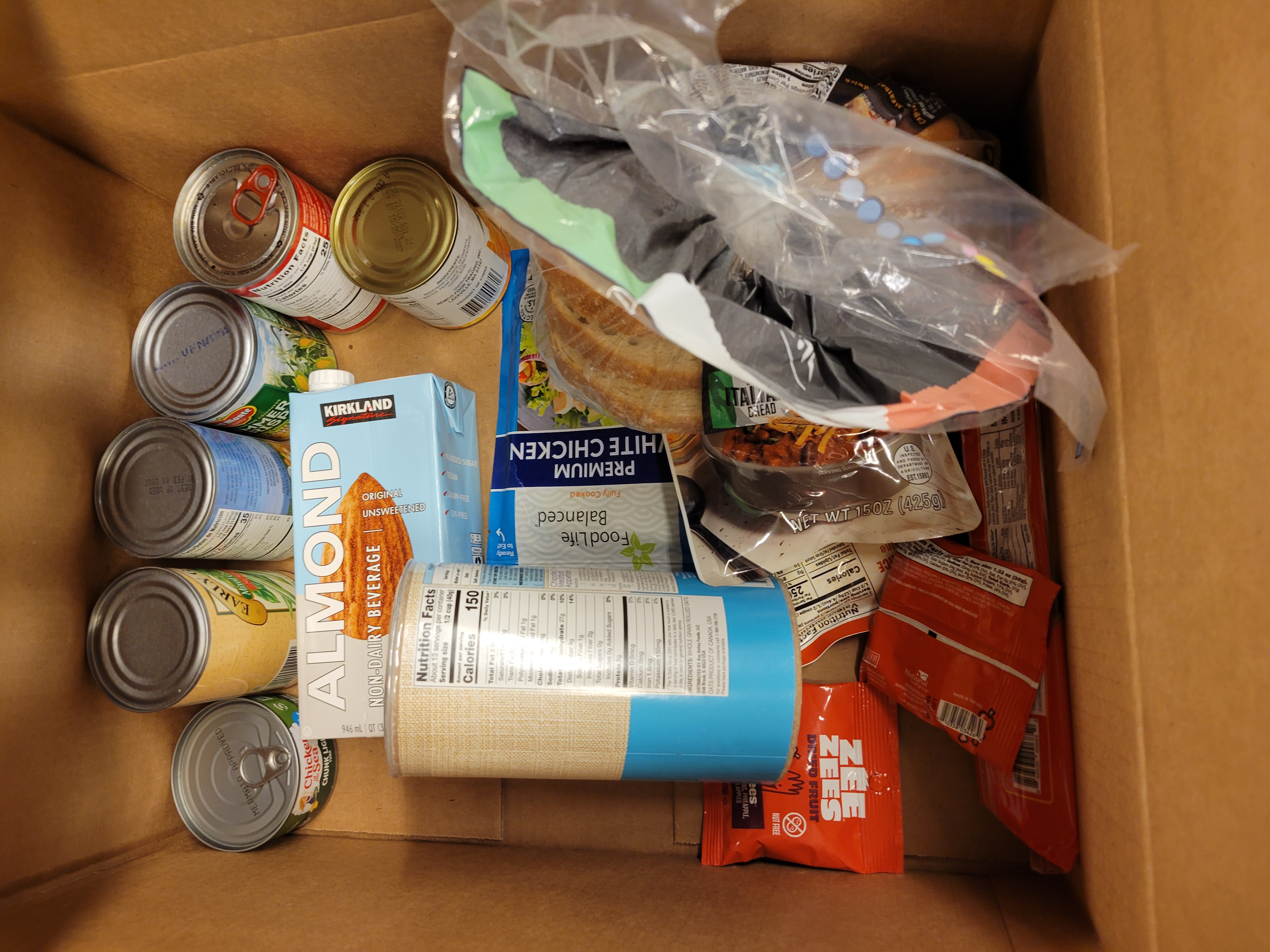 Cardboard box filled with bread and dry goods..